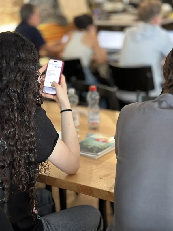 Teilnehmerin löst während des Theorieteils Fragen auf dem Smartphone
