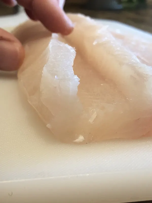 Sauber gelöstes, weisses Fischfilet auf dem Schneidebrett
