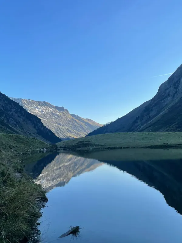 Spiegelglatter Bergsee im Tal am frühen Morgen