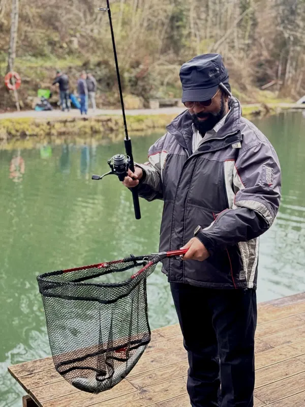 Teilnehmer landet am Forellenteich einen Fisch mit dem Kescher