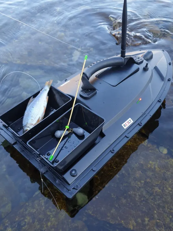 Futterboot mit Montage und Köderfisch auf dem Wasser