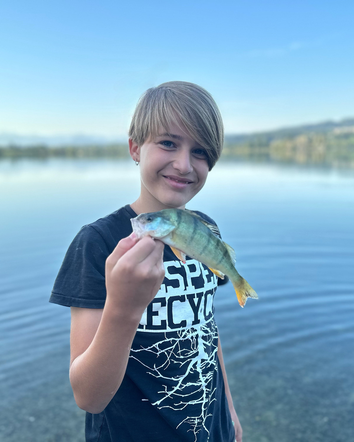 Jugendliche mit gefangenem Egli am See